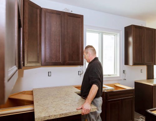 Guy fixing cabinet sized